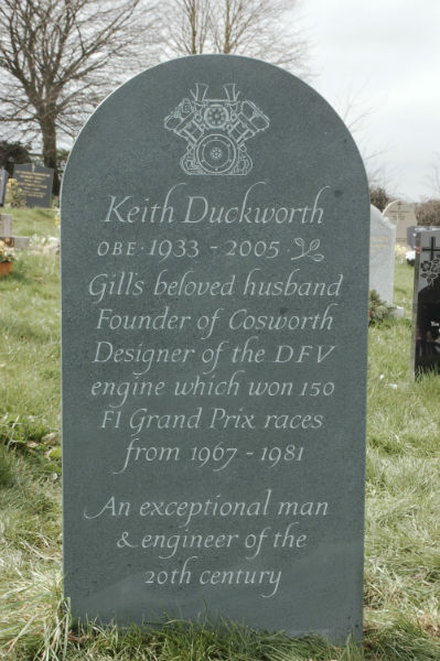 green slate headstone with line carving at the top
